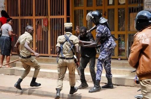 Ugandan security forces beat then detain a protester in downtown Kampala, Uganda, Monday, Aug. 20, 2018.