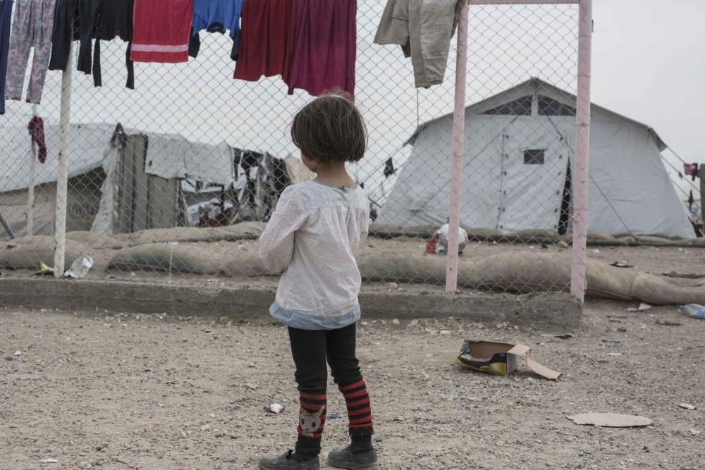 فتاة تقف في ملحق مخيم الهول في شمال شرق سوريا، الذي يضم أكثر من 11 ألف امرأة وطفل من 50 جنسية تقريبا من عائلات أفراد مشتبه بانتمائهم إلى داعش. يريد التحالف الكردي الذي يسيطر على شمال سوريا أن تستعيد بلدان الأصل النساء والأطفال. غير أن أغلب الحكومات استعاد