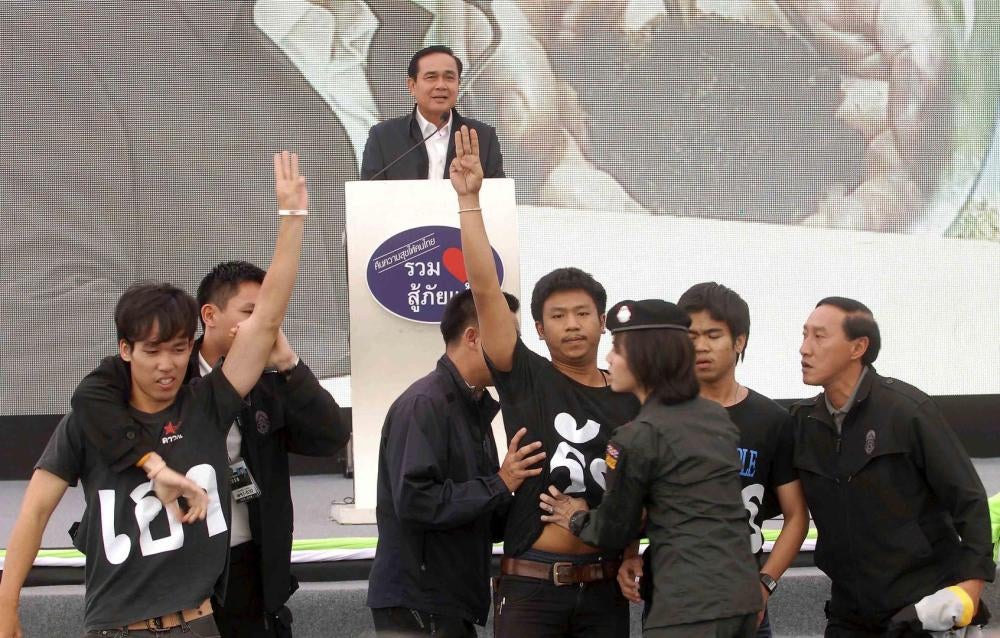 Estudantes tailandeses contrários ao governo fazem saudação de protesto enquanto o Primeiro Ministro Prayut Chan-ocha discursa na província de Khon Kaen, nordeste de Bangcoc. 14 de novembro de 2014.