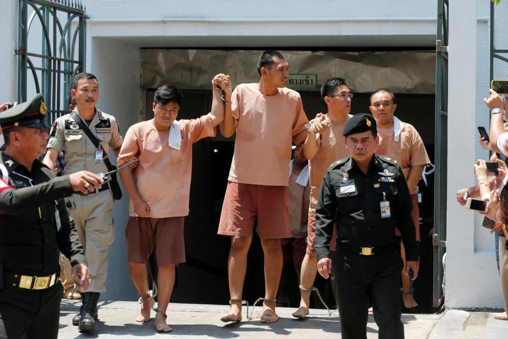 Quatre citoyens thaïlandais quittent le tribunal militaire de Bangkok, des chaînes au pied, le 10 mai 2016. Ils ont été inculpés de sédition et d'infractions informatiques suite à des posts sur Facebook critiques à l’égard du Premier ministre, le général 