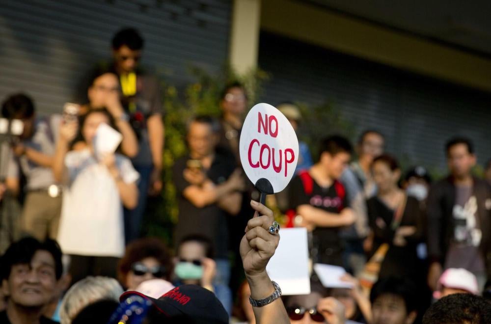 Presque quatre ans après le coup d’État par l’armée en mai 2014, un homme brandit une pancarte avec le message « No coup » lors d’une manifestation tenue le 10 février 2018 afin d’appeler les dirigeants militaires à organiser des élections.
