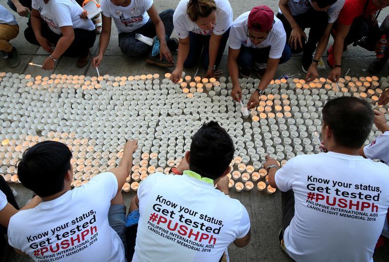 Campaign supporters lights on around 1,638 candles representing the number of dead victims claimed by HIV/AIDS in the Philippines since 1984 as part of their commemoration of International AIDS Candlelight Memorial Day in Quezon city, metro Manila in the 