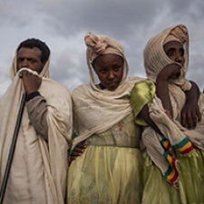 Three individuals face camera. 