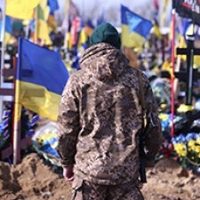 Individual with back to camera faces group of Ukrainian flags. 