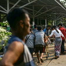 Figures walk through streets of Myanmar.
