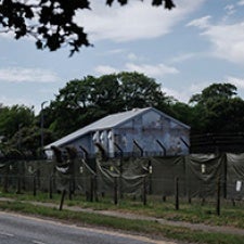 Building stands behind gate. 