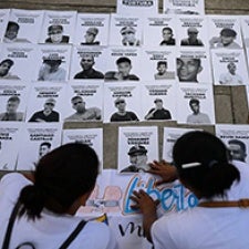 Two figures post missing posters. 