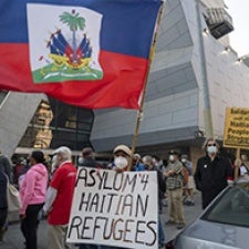 Protesters hold sign reading "Asylum 4 Haitian Refugees".