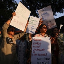 Protesters hold signs.