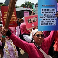 Protesters hold signs in street. 