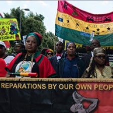 Protesters hold signs in street. 