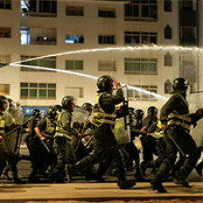 Student protesters face police. 