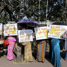 Protesters hold signs in Sri Lanka. 