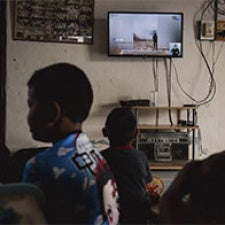Children sit in front of television. 