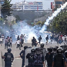 Protesters run amidst tear gas. 