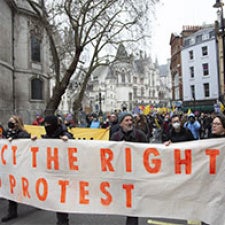Protesters hold sign reading "Protect the Right to Protest".