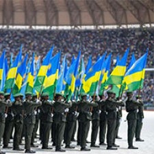 Military officials hold Rwandan flags.