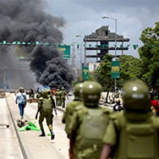 Smoke billows amidst police and protesters. 
