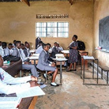 Teacher faces classroom of students. 