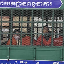 Prisoners sit on a prison transport vehicle in Cambodia