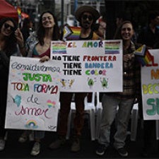 Group of protesters holding colorful signs. 
