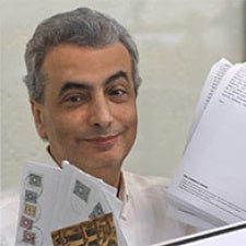 Lev Shlosberg holds papers and faces camera. 