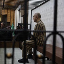 One figure is detained behind bars. 