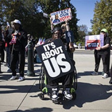Protesters hold signs reading "It's About Us".