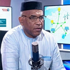 Journalist Abdramane Keïta sits in front of microphone.