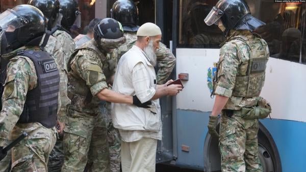 Russian law enforcement agents detain a Crimean Tatar man outside a court building in Simferopol, Crimea, September 4, 2021.