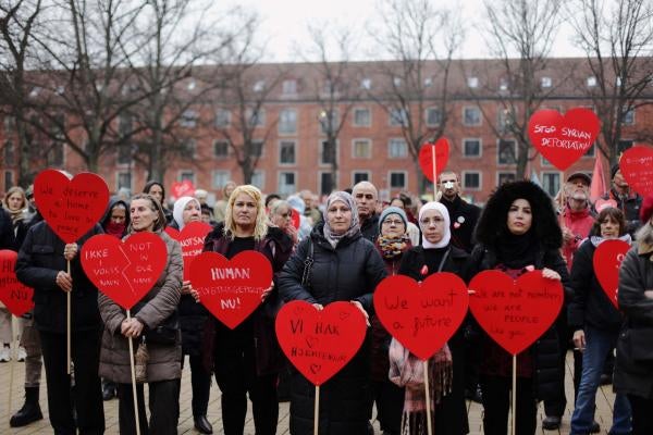 Protesters hold red heart-shaped signs