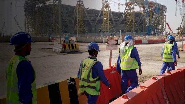 Workers walk toward the construction site of Lusail stadium, which is being built for the 2022 men's soccer World Cup, during a stadium tour in Doha, Qatar, on Dec. 20, 2019.