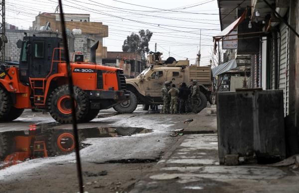 US soldiers and Syrian Democratic Forces standing by loader and military vehicles in East Ghweran neighbourhood at 2 p.m. on January 29, 2022.