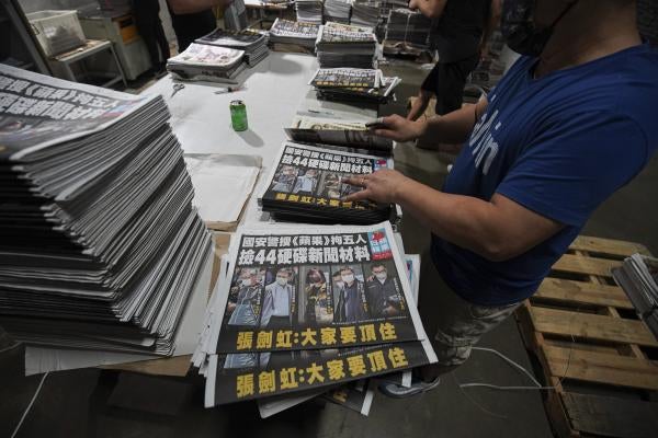 Workers pile Apple Daily newspapers at the printing factory in Hong Kong.