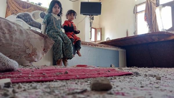 Girls in a bedroom of their house damaged by Saudi-led air strikes