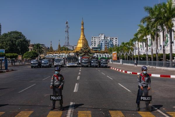 Police block a road leading to City Hall as protesters approach on February 13, 2021, in Yangon, Myanmar. 