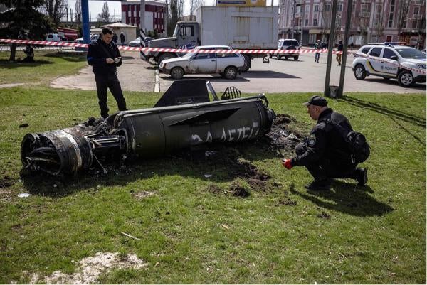 Ukrainian authorities inspect the rocket motor and guidance section of a Tochka-U missile next to the main building of the Kramatorsk train station in eastern Ukraine on April 8, 2022. The phrase “Payback for the children” is painted in Russian on the missile. 