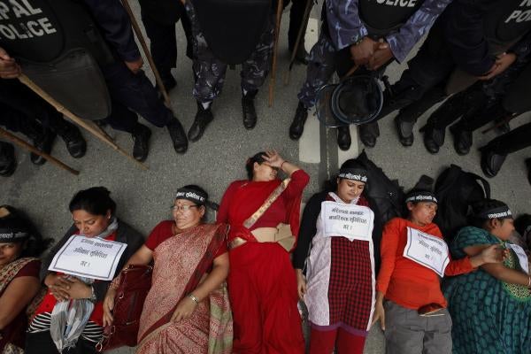 Nepalese women lie on the ground during a protest in Kathmandu