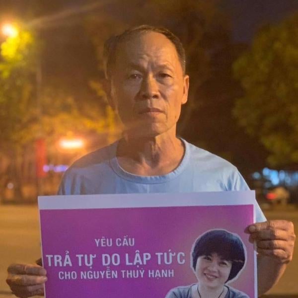 Truong Van Dung hold a sign that says, Request the Immediate Release of Nguyen Thuy Hanh. 
