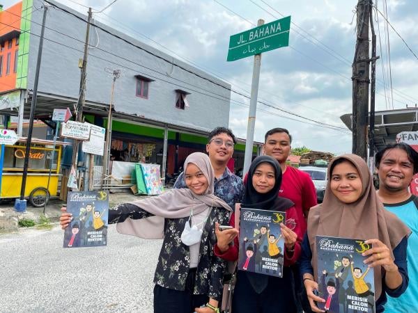Student journalists pose under a street sign in Pekanbaru, Riau, named for their magazine, Bihana, which played an important role in 1998 when local groups sought a bigger say in their province after President Suharto’s authoritarian rule.