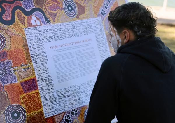 A member of the Gamay Dancers, a group performing in the Dharawal language, studies the Uluru Statement from the Heart, a document calling for an Indigenous Voice to Australia’s parliament, at an event celebrating Indigenous culture in Sydney, July 6, 2023. 