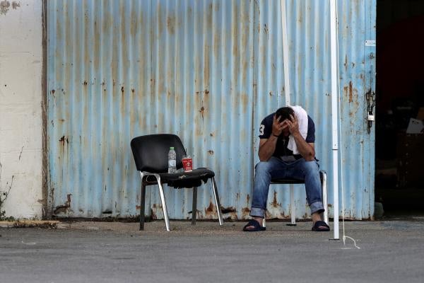 A man who was rescued at sea off the coast of Greece after the boat he and hundreds of other migrants and asylum seekers were on capsized sits at a shelter at the port of Kalamata, Greece, June 15, 2023.