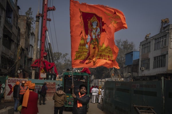 A man waves a flag with the Hindu god Ram to celebrate the opening of the Ram Temple in Ayodhya city, India, January 16, 2024.