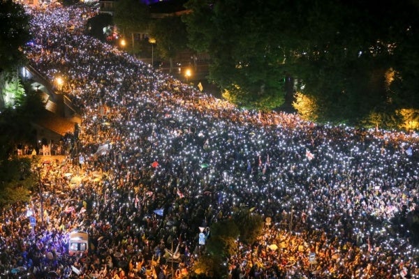 Demonstrators hold up their smart phones with the torch lights switched on during a protest rally against "the Russian law" in Tbilisi, Georgia, Saturday, May 11, 2024.