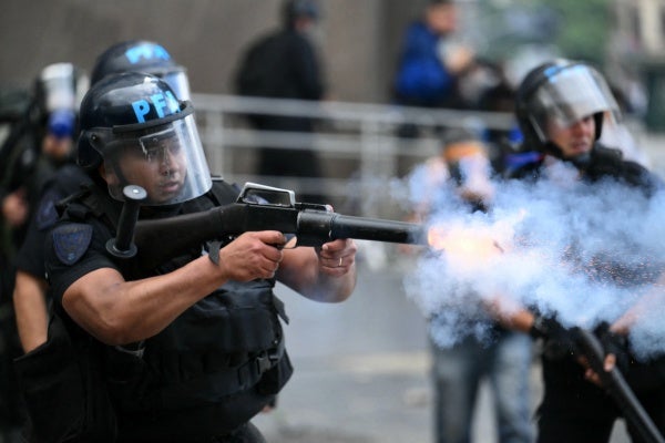 A riot police officer shoots a tear gas canister at protesters during a demonstration of pensioners calling for improvements to their pensions and access to free medicines, among other demands, in Buenos Aires on March 12, 2025.