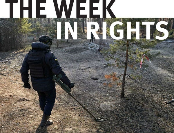 A figure walks through the woods.