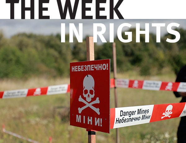 Landmine warning signs stand in field. 