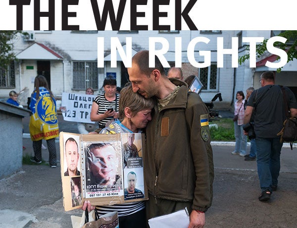 Protesters hold signs in Ukraine. 
