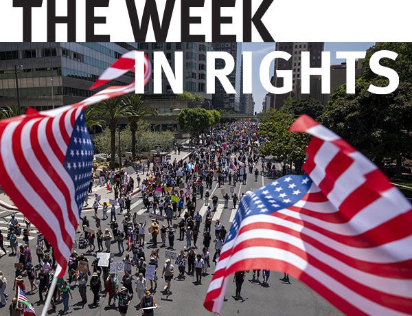 American flags fly over procession. 