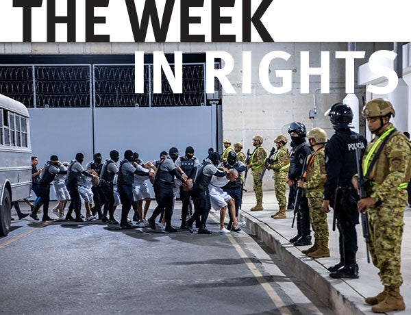 Authorities in military garb stand in line. 